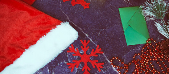 New Year and Christmas gifts. Selective focus. Santa claus hat, boxes with gifts, beads, Christmas toys on a dark background.