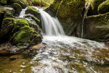 Long exposure of a waterfall on the Hoar Oak Water river flowing through the woods at Watersmeet in Exmoor National Park