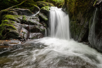 Obraz premium Long exposure of a waterfall on the Hoar Oak Water river at Watersmeet in Exmoor National Park