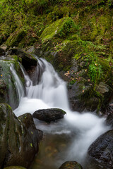Obraz premium Long exposure of a waterfall on the Hoar Oak Water river at Watersmeet in Exmoor National Park