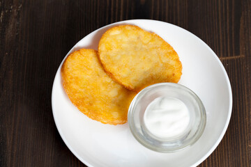 potato pancakes with sour cream on a plate