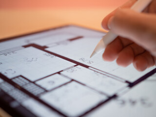 An architectural engineer is working on a floor plan of a building on a mobile