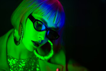 Portrait of glamorous woman under neon green light. Nightclub, trendy outfit. Teenager, zoomer Z-generation. Copy space