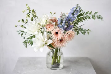 Tuinposter Finished flower arrangement in a vase for home. Flowers bunch, set for interior. Fresh cut flowers for decoration home. European floral shop. Delivery fresh cut flower. © malkovkosta