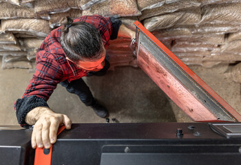 A man looking into a boiler on solid fuel, open door boiler with flames of fire.