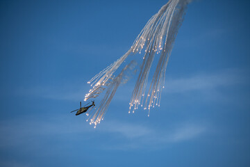 Low angle shot of an aircraft with fireworks in the blue clear sky - Powered by Adobe