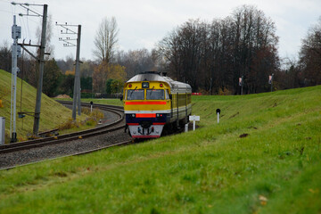 a beautiful train in the city on winding railroad tracks in the mountain valley in autumn
