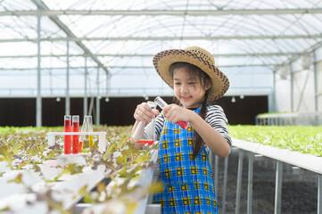 Happy cute girl learning and studying in hydroponic greenhouse farm, education and scientist concept