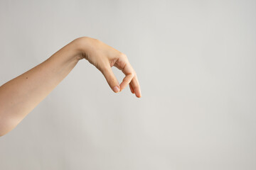 Hand gestures. Elegant female hand holding something with two fingers