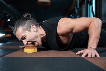 young man push up and dieting and want eat sweet cake on workout