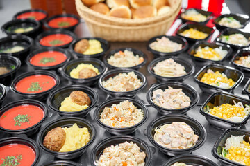 Food delivery. Different in plastic disposable lunch box with healthy natural food. Chicken broth, mashed soup, mashed potatoes with cutlet, seafood pasta, salads, pilaf with a fresh bun.