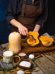 The cook cleans the orange pumpkin from the seeds. Prepares the filling for pumpkin pie. Classic recipe, lots of ingredients. Step-by-step recipe, cookbook, cooking blog, restaurant, home cooking.