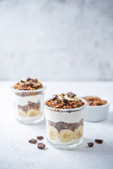 Chocolate and banana Greek yogurt granola parfait in a glass