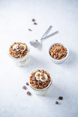 Chocolate and banana Greek yogurt granola parfait in a glass