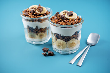 Chocolate and banana Greek yogurt granola parfait in a glass