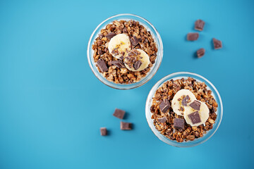 Chocolate and banana Greek yogurt granola parfait in a glass