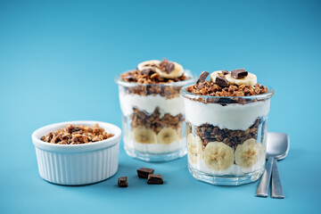 Chocolate and banana Greek yogurt granola parfait in a glass