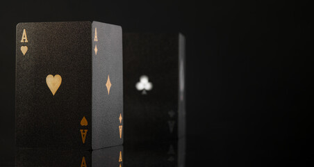 Black poker cards on a black background. Stylish composition. Close-up. Three-dimensional image. No people. Casino, online casino, gambling, strategy games, gambling, poker. - 464918895