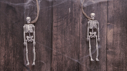 toy skeletons of a man on a rope on a wooden background , Halloween concept