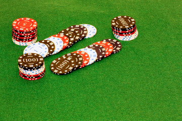 Piles of gambling tokens on a green background