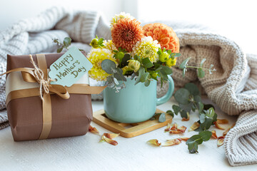 Spring composition for mother's day with a gift and chrysanthemum flowers.