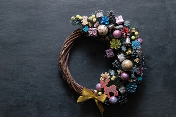 Christmas wreath with colored decor on black background