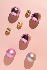 Christmas composition with pink and silver decorative balls on a pastel pink background. Minimal New Year concept.