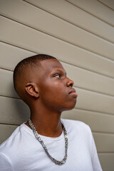 Afro young man looking up against a wall