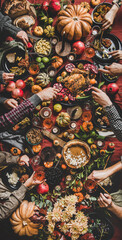 People eating and drinking wine at Thanksgiving table, vertical composition