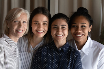 Smiling faces of friendly colleagues. Team portrait of four females coworkers of different age...