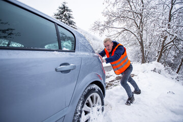 Man pushing car in snow
