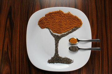 Tree drawing with spices. Spoon of spices and seeds, curry, and flaxseeds.