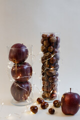 autumn composition, apples and chestnuts in a vase, table decoration, interior decoration, autumn fruits, vase with a garland, New Year mood