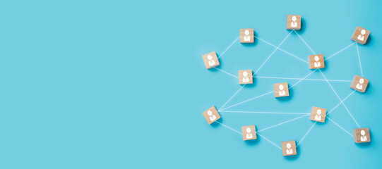 Wooden blocks with people icon connected together on blue background. Teamwork, network and...