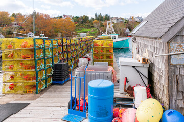 Fototapeta premium A lobster boat and it's wire mesh lobster traps sit in harbour waiting for the start of the lobster fishing season. Shot on Nova Scotia's Soputh Shore in fall.