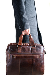 man in a coat holds a leather bag.