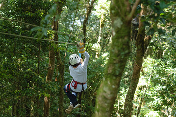 Joven adolescente colgando de cables para canopy en la selva de costa rica 