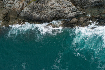 Obraz premium Aerial view of sea crashing waves White foaming waves on seashore rocks Top view Rocky coast