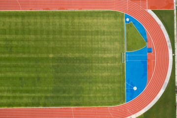 Aerial view of empty new soccer field from above with running tracks around it Amazing new small...