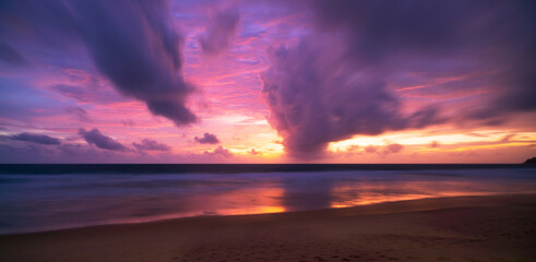 Beautiful motion blur long exposure sunset or sunrise with dramatic sky clouds over calm sea in...