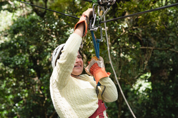 Mujer colgando y divirtiéndose  en cables de canopy de la selva en costa rica