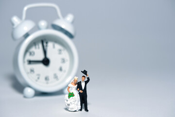 Wedding time and schedule concept miniature people, toys photography. Bride and groom standing in...
