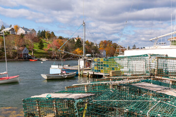  A lobster boat and it's wire mesh lobster traps sit in harbour waiting for the start of the lobster fishing season. Shot on Nova Scotia's Soputh Shore in fall. - obrazy, fototapety, plakaty
