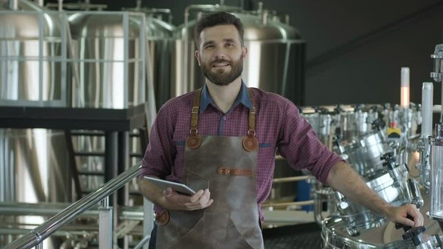 Young male brewer works at a modern brewery