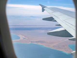 Aerial view above the clouds and sky, Inspiration concept. Travel freedom by air. Flight, view from the airplane to tropical sea with corals. Turbo-jet aircraft engine, transport 4k. Passenger airbus