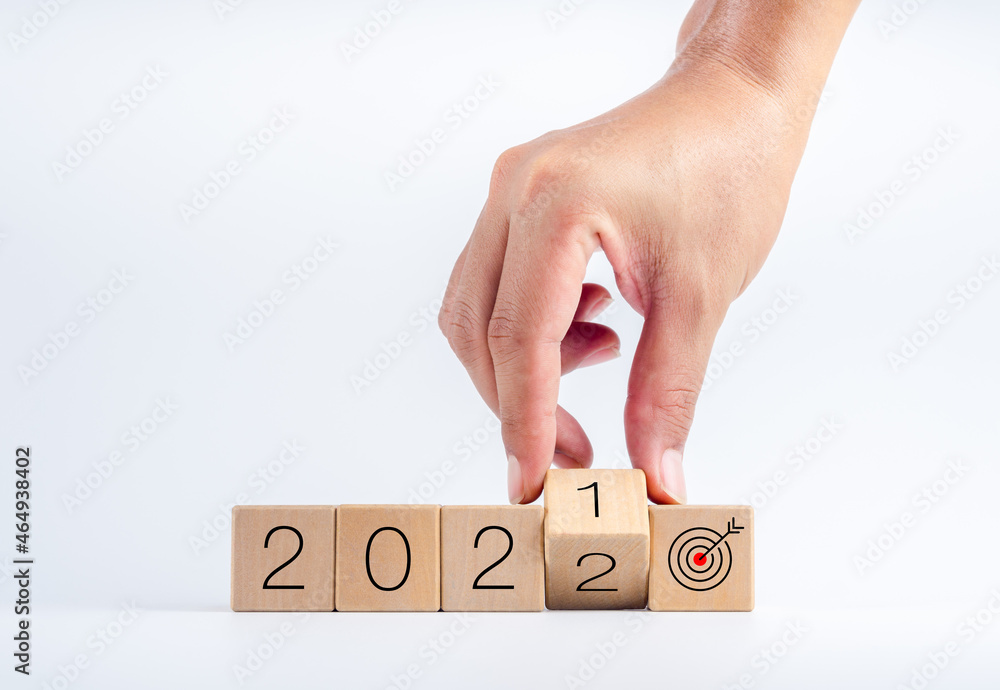 Poster the calendar year 2021 changed to 2022 with the goal and successful concept. hand turning wooden cub