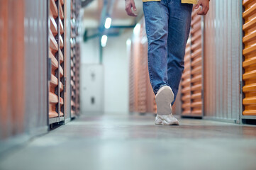 Legs walking in basement between boxes