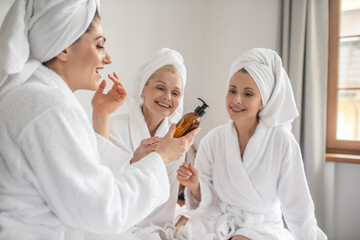 Women in bathrobes trying new cosmetic