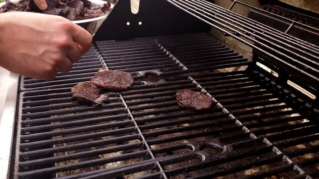 Home cooking - Transferring dehydrated or dried beef jerky back on smoker for further flavor enhancement.