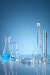 Front view of scientist working with chemical reaction in chemistry laboratory. . Blue liquid in transparent test tube and blue blackground with blank space for advertising